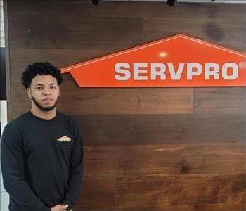 male, posing front of brown servpro sign