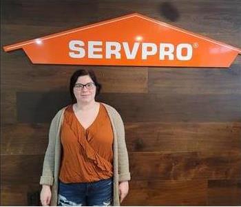 female posing in front of servpro sign
