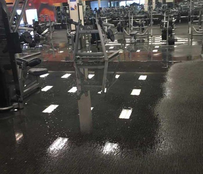 pooling water on floor of fitness center, equipment metal in it