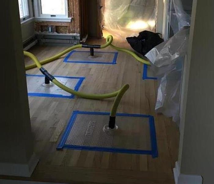 drying mats working on a hardwood floor with yellow hoses