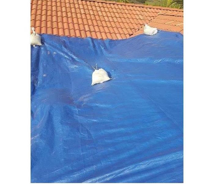 blue tarp covering tile roof